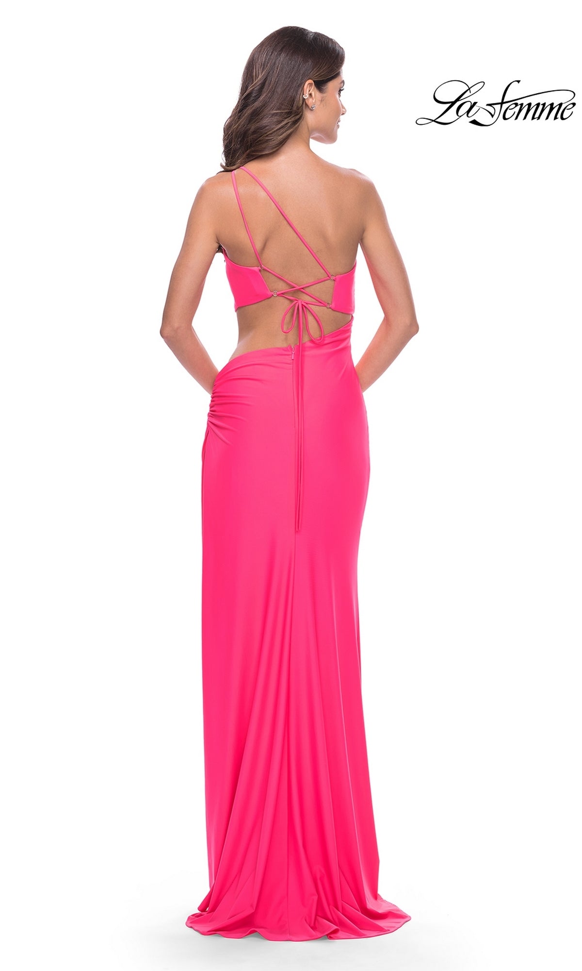 A woman is shown from behind wearing the La Femme Long Prom Dress 31443, a fitted bright pink gown with a low back and crisscross straps, set against a white background. The La Femme logo appears in the top right corner.